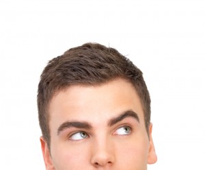 Close-up of businessman looking up against white background